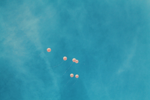 Pink balloons floating in the sky.