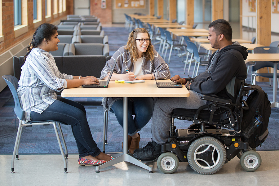 Three students sitting around a table.