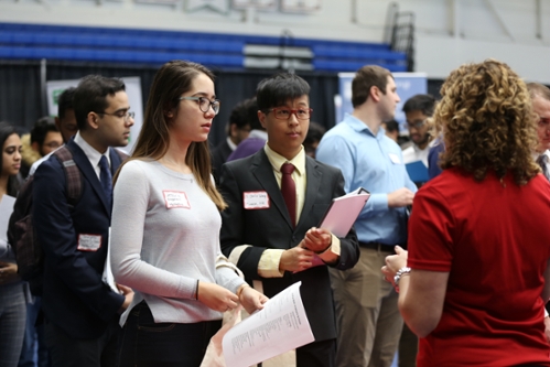 Students speaking with a company representative at the Job Fair