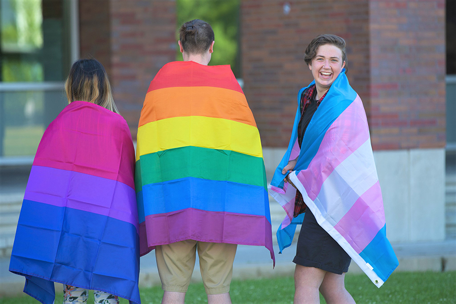 Students supporting equity and inclusion holding Pride flags.