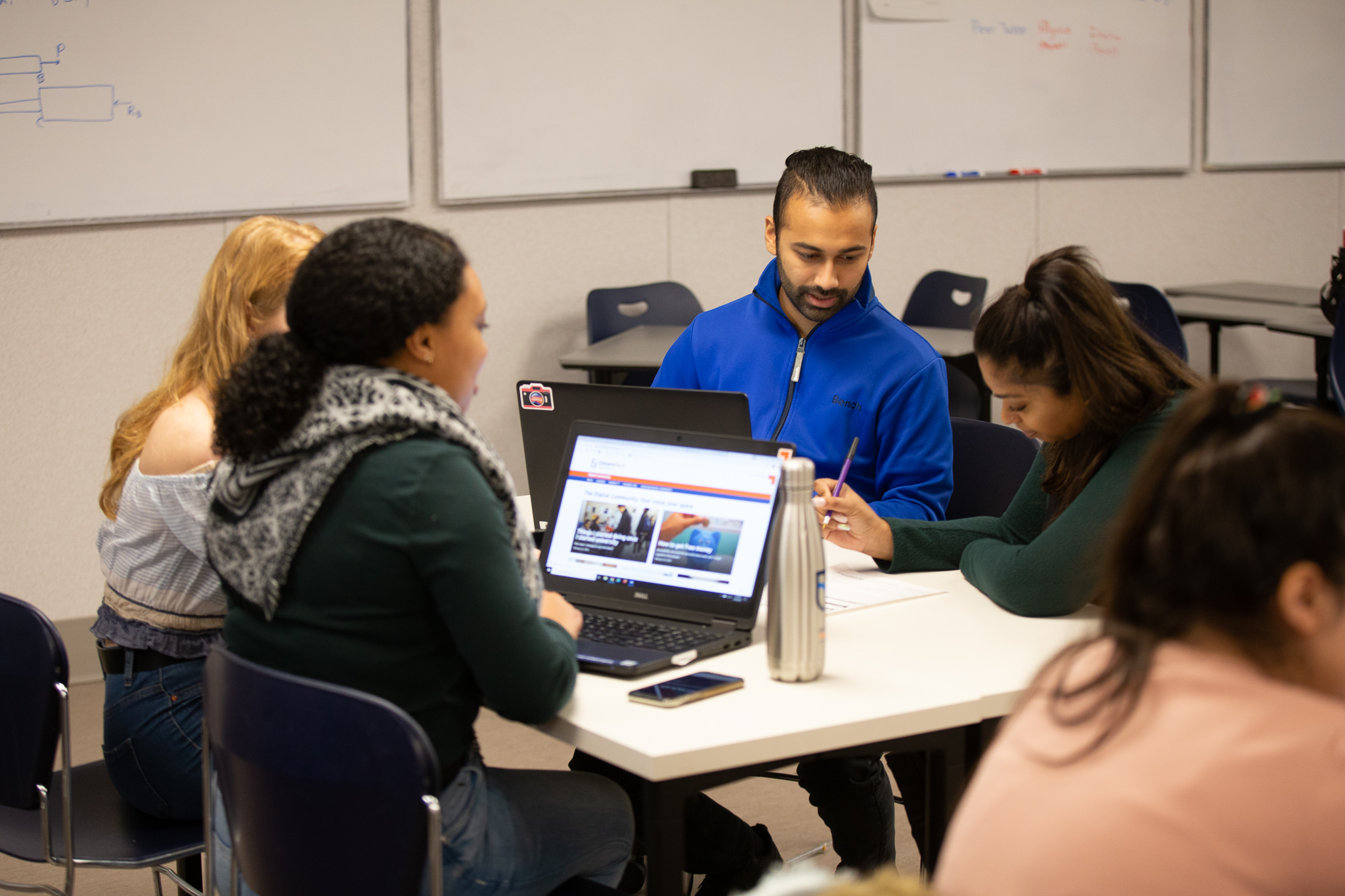 Students sitting around a table talking.