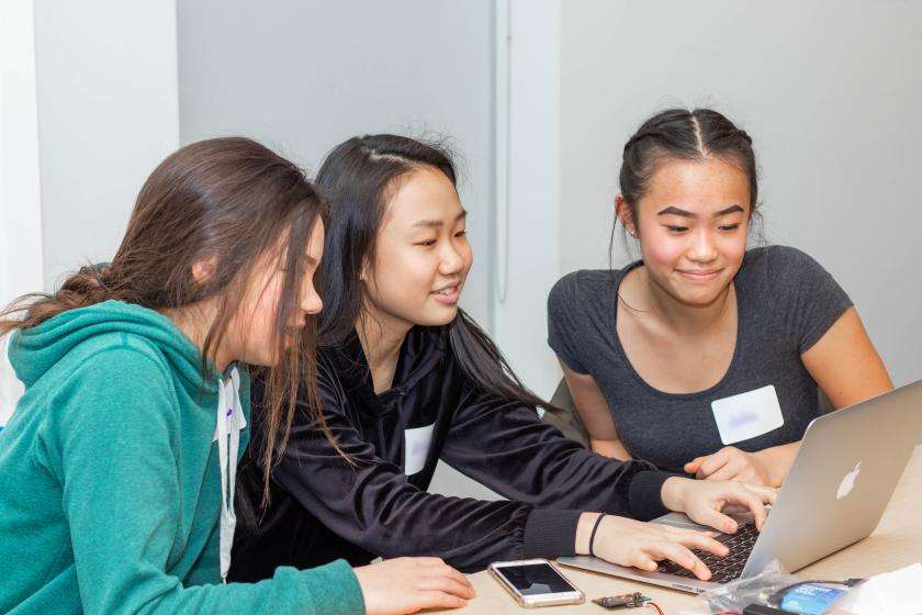 3 female students seated around a computer at GoEngGirl 2019