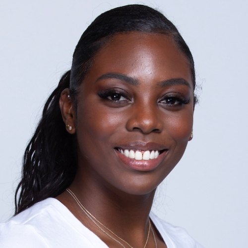 Headshot of a smiling young woman with dark hair pulled back, wearing a white shirt and displaying a warm expression.