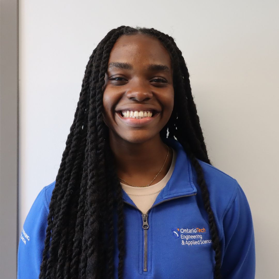 Smiling woman wearing a blue Ontario Tech University sweatshirt.