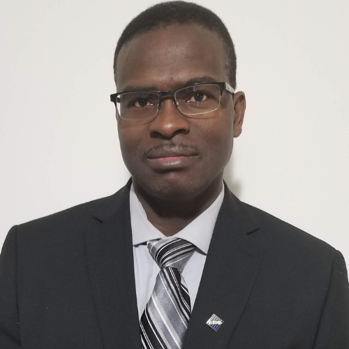 Professional portrait of a man in a suit and tie, wearing glasses, showcasing a confident demeanor.