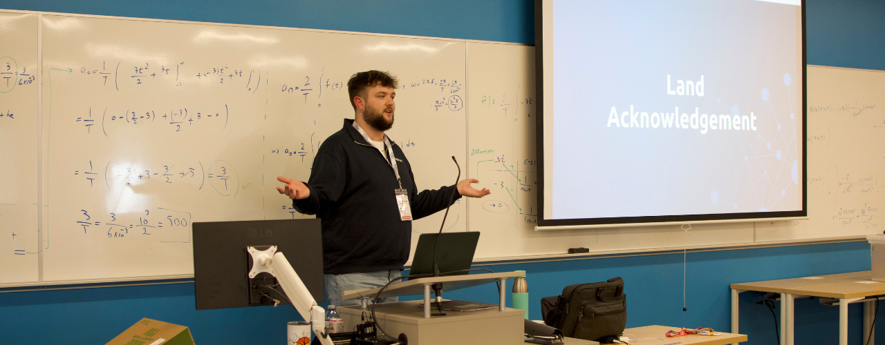 a photo of an instructor teaching at the front of the room