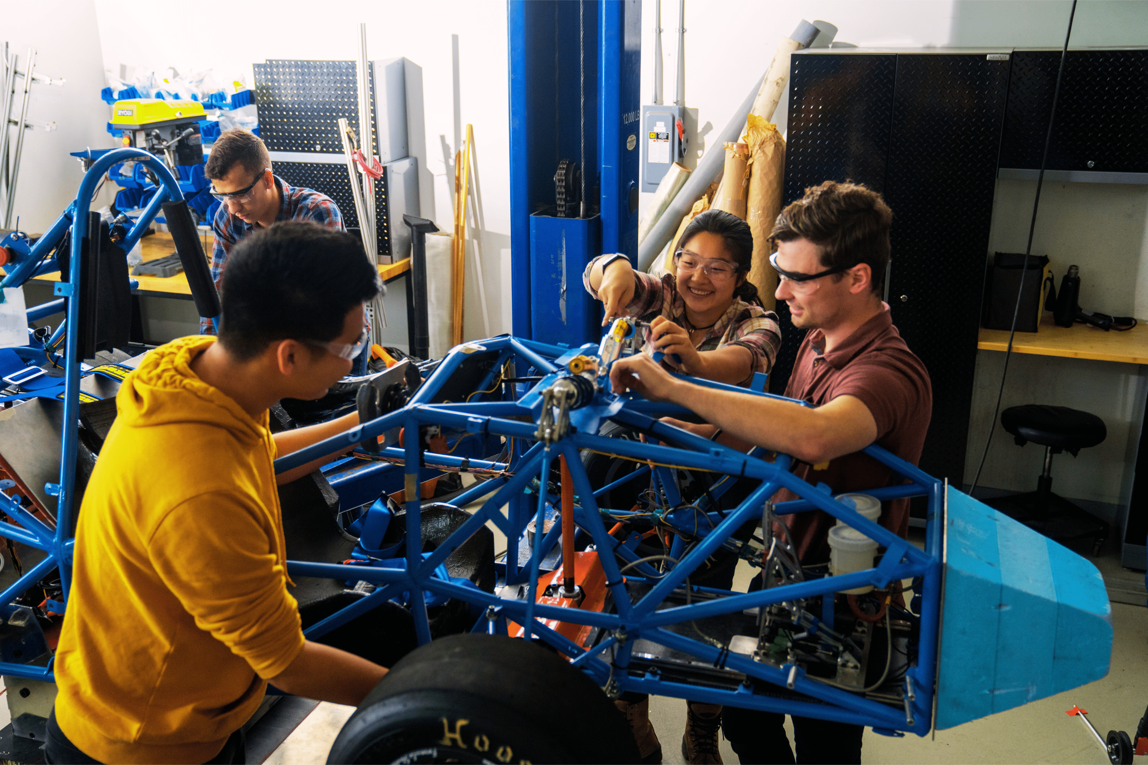 students working on a car
