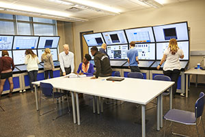 An image of students in a classroom in front of computers.