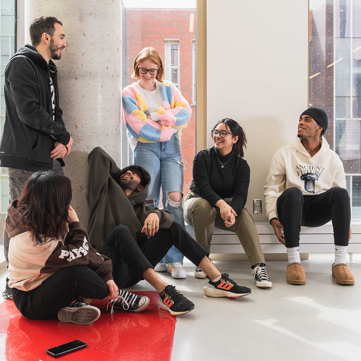 Students hanging out in Shawenjigewining Hall